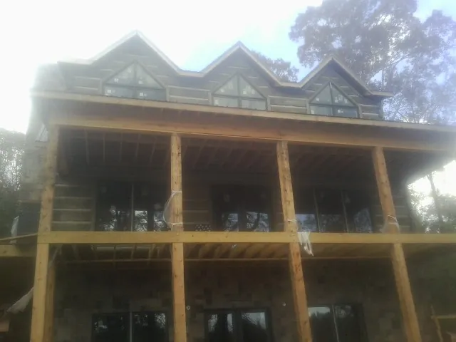 Dormers and porch framing on a large log home under construction — Roof Coating work by our crew in Peoa